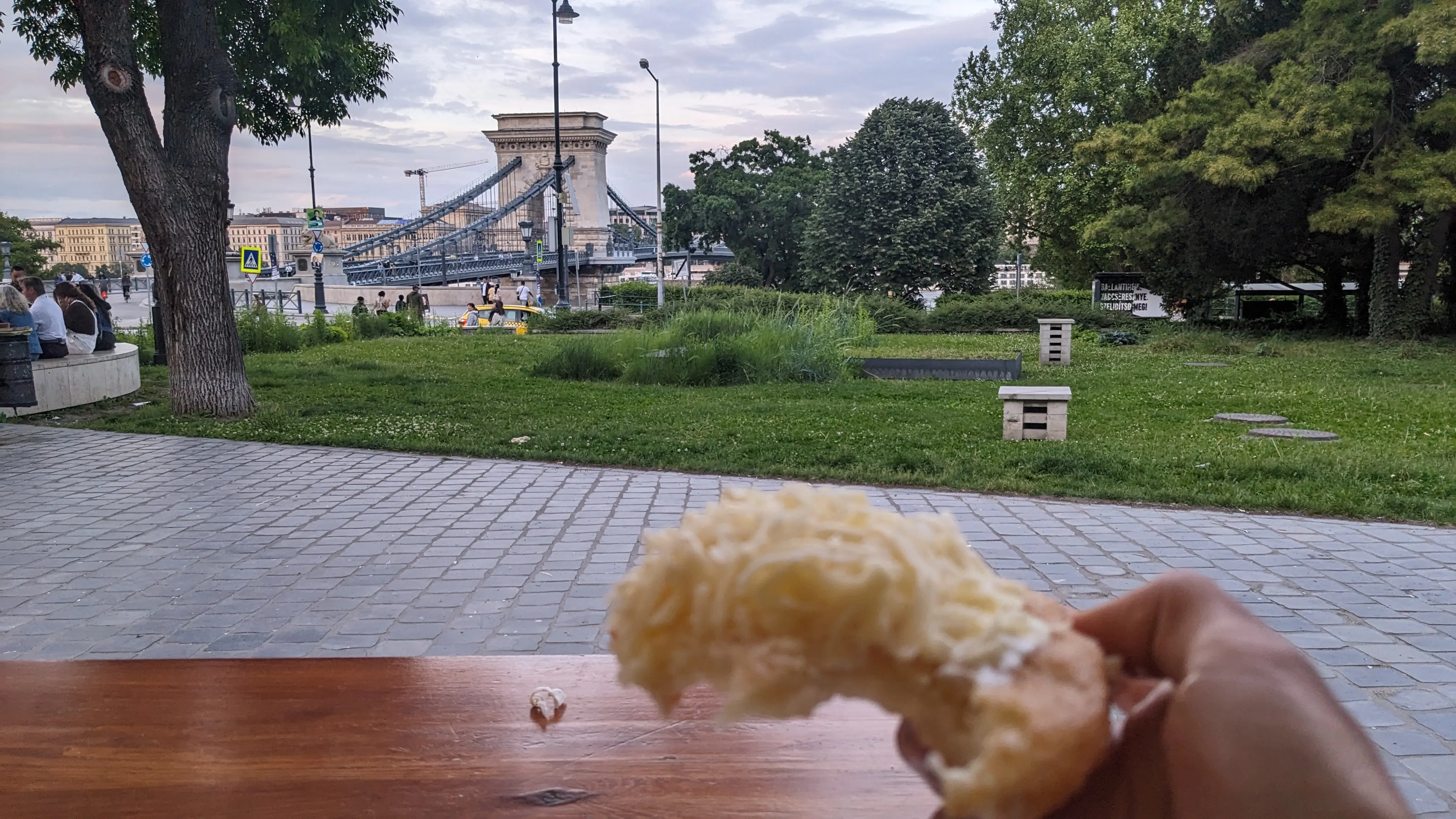 Eating Lángos with sour cream and cheese by the Danube river
