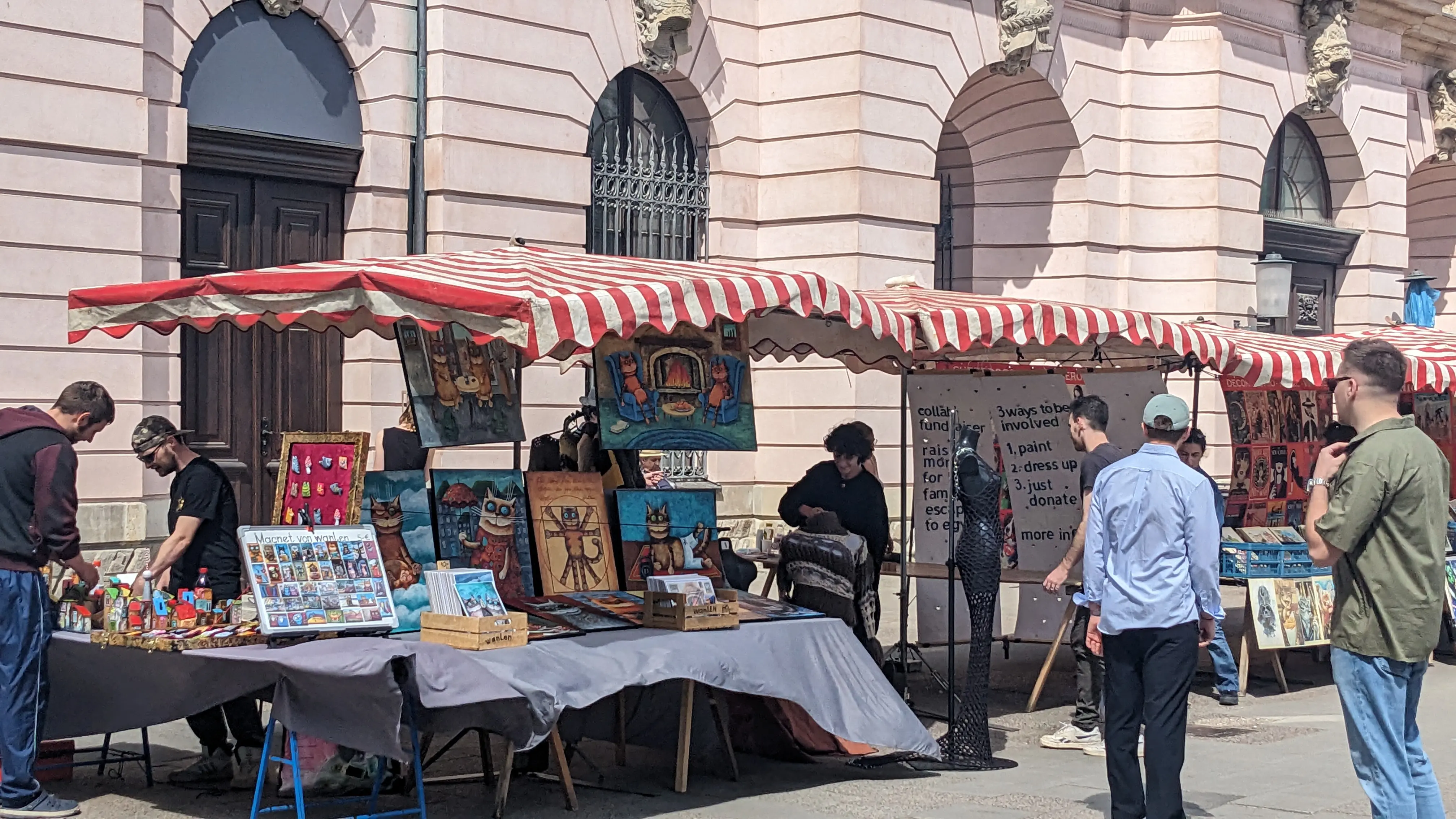 A seller selling cat paintings in a market